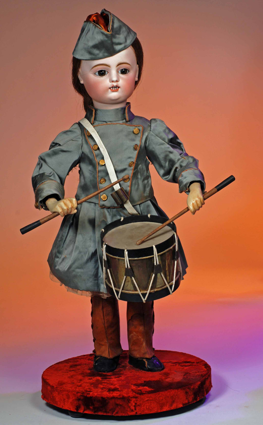 French bisque automaton drummer by Roullet & Decamps, all original, circa 1900, head turns side-to-side as it beats the drum, 28 inches, Estimate: $6,000-$9,000. Image courtesy of Frasher’s Doll Auction.